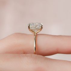 a woman's hand with a ring on it that has a diamond in the middle