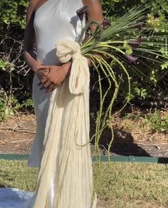 a woman in a white dress holding a plant