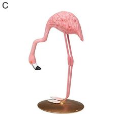 a pink flamingo standing on top of a metal base