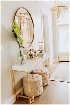 a white table with two stools and a mirror on the wall in front of it