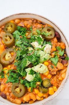 a bowl filled with beans and vegetables on top of a table