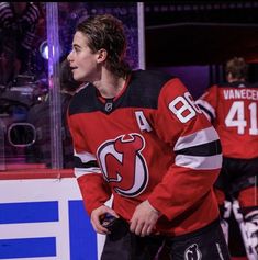 a hockey player standing on the ice with his hands in his pockets and looking off into the distance