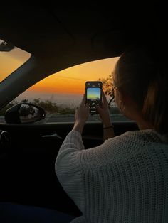 a woman is taking a photo in the back seat of a car with her cell phone