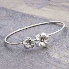 Like radiant stars frangipani blooms in a design by Aoy. The flowers center a sleek cuff bracelet that is crafted by hand of sterling silver. .925 Sterling silver Adjustable Silver Flower Bangle, Silver Bracelet Designs, Modern Silver Jewelry, Silver Jewelry Diy, Pretty Jewelry Necklaces, Hook Bracelet, Birthday Bracelet, Silver Bangle Bracelet, Sterling Silver Bangle Bracelets