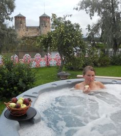 a woman sitting in a hot tub with fruit