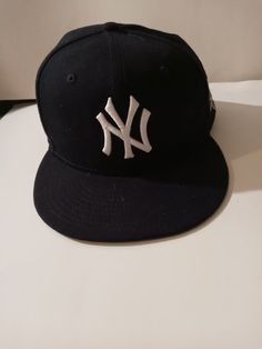 a new york yankees baseball cap sitting on top of a white table next to a wall