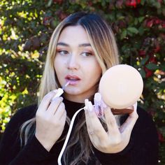 a woman holding an ice cream cone and plugged in her ear