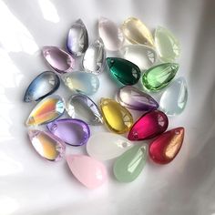 many different colored glass beads on a white surface