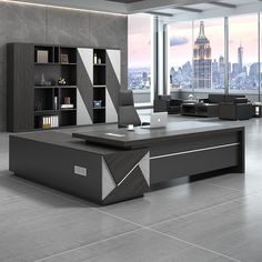 an office desk in the middle of a room with large windows and floor to ceiling bookshelves