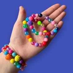 Brighten up any outfit with these handmade elastic rainbow bead bracelets! Each one is unique and adds a pop of color to your style. No need to worry about matching - mix and match colors for a fun and vibrant look. (Colors may vary slightly due to their handmade nature.) Cheap Novelty Rainbow Beaded Bracelets, Trendy Multicolor Stretch Bracelet For Party, Fun Rainbow Bracelets For Parties, Fun Rainbow Bracelets For Party, Rainbow Round Beads Stretch Bracelet For Friendship, Cute Multicolor Stretch Bracelet For Party, Casual Rainbow Stretch Bracelet With Round Beads, Trendy Rainbow Beaded Bracelets, Playful Handmade Plastic Stretch Bracelet