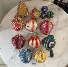 a marble table topped with ornaments on top of it's sides and in different colors