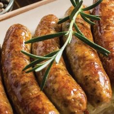 sausages with rosemary garnish on top of bread