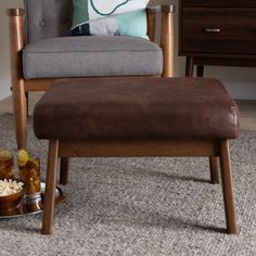 a chair and ottoman in a living room with food on the floor next to it