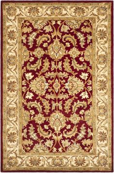 a red and beige rug with an ornate design on the bottom, in gold trimmings