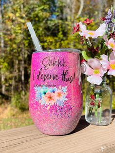 a pink glitter tumbler next to a vase with flowers in it and the words, sunshine doesn't give up