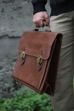 Vintage 50s 60s brown leather briefcase. Thick high quality relief leather in brown color. Two tuck catch closures and movable handle. Inside 3 big compartments, one you can close with zipper. Buckle says on its back: Swiss made Measurements: width 45 cm height 32 cm without handle/ 37 cm with handle depth 14 cm weight 1490g / 2000g including packaging Great vintage condition, some minor scratches on metallic hardware and corners of the leather, also inside of the bag there are discolorations an Vintage Briefcase Aesthetic, Vintage Rectangular Briefcase For Business, Vintage Business Briefcase Rectangular Case, Vintage Rectangular Business Briefcase, Vintage School Satchel With Hasp Closure, Vintage Briefcase With Leather Lining, Retro Satchel Briefcase, Brown Business Briefcase With Hasp Closure, Vintage Briefcase With Leather Lining For Daily Use