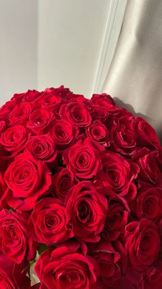 a bouquet of red roses sitting on top of a table