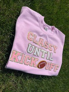 "\"Classy until kickoff\" real chenille letter t shirt or crewneck sweatshirt. Shirt can be customized in any color shirt and letters! Customize colors to match your favorite NFL team or your son's football team! Shirt also features adorable football chenille patch. Get ready for Sunday kickoff with your own custom football shirt. Need this ASAP? see bottom of listing for rush order link ⭐️ Crewneck sweatshirt is a unisex Gildan size small-XL. See size chart in listing pictures. 50% cotton, 50% polyester. Short sleeve t shirt is made with a unisex gildan 100% cotton t shirt ⭐️ See photos for sweatshirt colors. Custom requests welcome!! ⭐️ Letter colors include white, pink, blue, purple, black, red, lime green, hunter green, and yellow. Don't see the color letters you are looking for? Messa Custom Football Shirts Ideas, Puffy Letter Sweatshirt, Customizable Team Spirit Sweatshirt For Cheerleading, Customizable School Spirit Sweatshirt For Cheerleading, Diy Sports Shirts, Customizable Varsity Sweatshirt For Sports Season, Customizable Casual Sweatshirt For Football Season, Customizable Sporty Sweatshirt For Game Day, Customizable Crew Neck Sweatshirt For Cheerleading