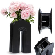 a black vase with pink flowers in it