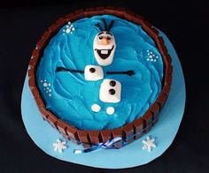 there is a cake with frosting and decorations on the top that looks like characters from disney's frozen world