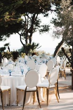 the tables are set up with white linens and blue glassware for an elegant wedding reception