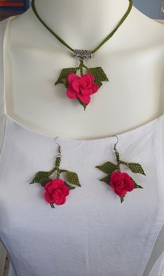 two necklaces with flowers attached to them on a mannequin