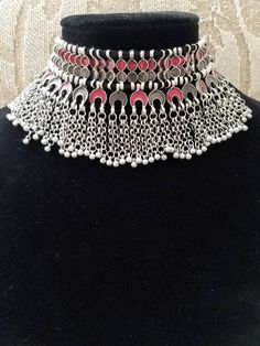 Stand out wearing this striking boho choker in red and soft smokey gray enamel, on oxidized silver so as to create the patina of a vintage tribal piece. Strung on black cotton threads. Maximum length 8 in. Adjustable length using sliding knot, to ensure a perfect fit for you. Wear high up as a choker or lower down, peeking out of a button up shirt. Or on the outside of the shirt. Mesmerizing movement with tiny bells. You will be noticed! And complimented! Shop chokers: https://www.etsy.com/shop/ Metal Choker With Oxidized Finish, Silver Choker For Festivals, Silver Choker Necklace For Festival, Adjustable Festival Choker, Oxidized Finish Choker Necklaces For Festival, Oxidized Choker Necklace For Festival, Oxidized Finish Choker Necklace For Festival, Bohemian Choker For Festivals, Traditional Red Choker For Festival