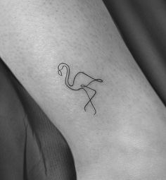 a small flamingo tattoo on the ankle is shown in black and white, with an outline