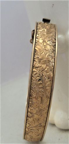 "A beautiful gold filled bracelet by Winard The etching is a floral design It has a safety chain. The diameter is 2 1/4\" the width is 3/8\" and the weight is 14.30 g it is marked winard 1/20 12kt Inside dimension is about 6.50\" It is for a small wrist. I did not see any issues If you have any questions please convo me BEFORE purchase I will be happy to help you . My vintage shop has a no refund policy Thanks for snooping in my attic :)" Antique Gold Cuff Bracelet Collectible, Antique Etched Gold Bracelets, Antique Etched Gold Bangle Bracelet, Antique Gold Cuff Bracelet With Filigree, Antique Etched Gold Bracelet, Ornate Gold Etched Bangle, Antique Etched Yellow Gold Bracelets, Antique Engraved Yellow Gold Cuff Bracelet, Antique Gold Stamped Bracelets