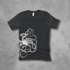 Women's Bella Tri-Blend relaxed unisex fit T-shirt with an Octopus screen printed graphic design.  Super soft, stretchy, and comfy material.   Available with black or white ink! FIT: Follow the image size chart Unisex Fit - Runs Large - Long Length  Suggest sizing down if you prefer a more fitted look instead of relaxed -  Bella 3.8 oz  Super Soft hand and lightweight  -  Tri Blends:  50% Poly, 25%  Cotton, 25%  Rayon -  Does not shrink -  Hand screen printed to order in Oregon - Model is wearing a size small Fashion Fitted Style  http://etsy.me/2qjx3lC ♥ All of our tees are hand-printed to order in our shop in Portland Oregon! ♥ RETURNS & EXCHANGES We gladly accept exchanges and returns if not worn.   Please follow the chest measurement size guide for fit if you are unsure.  We custom pri Graphic Tee With Front Print In Ring-spun Cotton, Gray Band Merch T-shirt With Graphic Print, Band Merch Crew Neck Shirt With Front Print, Graphic Tee With Sublimation Print And Crew Neck, Sublimation Print Crew Neck Graphic Tee, Gray Relaxed Fit T-shirt With Front Print, Gray Band Merch T-shirt With Screen Print, Band Merch T-shirt With Front Print And Crew Neck, Black T-shirt With Sublimation Print In Ring-spun Cotton