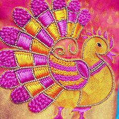 a close up of a colorful bird on a pink and gold cloth with an intricate design