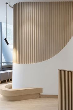 the interior of a modern building with curved walls and wooden slats on the wall