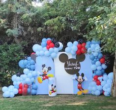 a mickey mouse birthday party with balloons and decorations