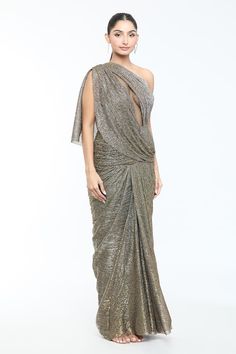 Antique gold draped dress with crystal embellishment and one shoulder cape style sleeve. - Aza Fashions Glamorous Draped One-shoulder Dress For Formal Occasions, Glamorous Draped One Shoulder Dress For Formal Occasions, Glamorous Draped One Shoulder Dress For Formal Events, Glamorous Pre-draped Saree With Cape Sleeves, Draped Evening Dress With Draped Sleeves For Gala, Glamorous Party Pre-draped Saree With Cape Sleeves, Embellished Pre-draped Saree With Cape Sleeves For Evening, One Shoulder Draped Dress For Evening, Draped One Shoulder Dress For Evening