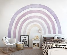 a bedroom with a bed, chair and rainbow wall mural