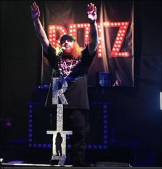 a man standing on top of a stage with his arms in the air