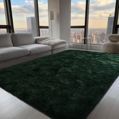 a living room filled with furniture and large windows overlooking the cityscape in the distance