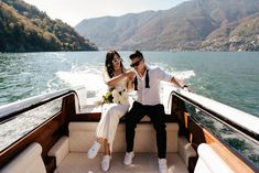 a man and woman sitting on the back of a boat