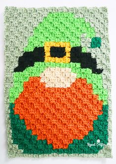 a crocheted square with an image of a lepreite wearing a hat