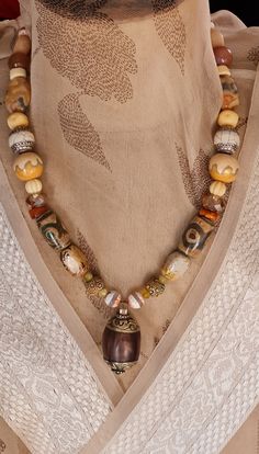 Welcome to my store. Please check all dimensions given. This large vintage Repoussé Tibetan bead is decorated with traditional pattened brass top and bottom. The palette for this necklace is warm and earthy. As well as a couple of my hand made beads, I have used inlaid agate in the style of Tibetan Dzi beads, Afghan Calcite, Superb antique African trading beads, Picture Jasper, pumpkin carved bone beads, polished river stone  and carnelian spacers. This is a 'One of a Kind' As stated in other posts, I can lengthen or shorten to suit and earrings can be made to accompany. Take a look at my personalization policy. Brown Polished Beads Jewelry For Festival, Unique Brown Beads For Festivals, Bohemian Brown Necklace With Large Pendant, Unique Brown Polished Beads, Festival Brown Jewelry With Polished Beads, Festival Style Brown Beads, Festival Brown Polished Bead Necklaces, Festival Brown Polished Bead Necklace, Festival Brown Polished Beads Necklace