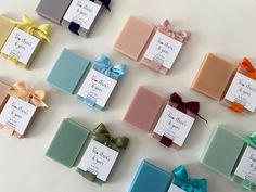 many different colored soaps with bows on them are arranged in the shape of rectangles