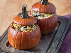 two pumpkins with stuffing in them sitting on a tray