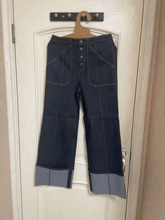 a pair of jeans hanging on a door hanger