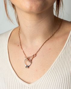 a woman wearing a necklace with an arrow on it