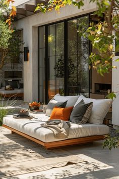 an outdoor living area with couches, tables and potted plants