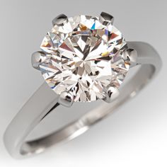 a round brilliant cut diamond ring on a white background