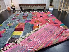 a multicolored rug is on the floor next to a bench