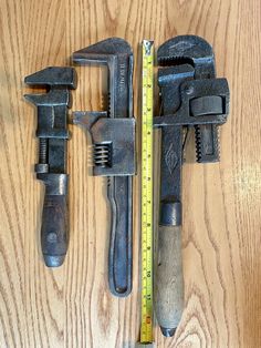 two wrenches and a ruler on a wooden table