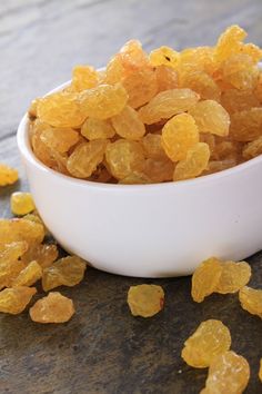 a white bowl filled with raisins on top of a table