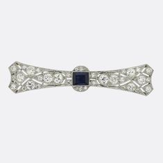 This is an Art Deco sapphire and diamond brooch from the luxury French jewellery designer LaCloche Frères. The brooch is crafted in platinum and the central sapphire is a mid to dark blue hue. The darker tone of the sapphire emphasises the bright white sparkle of the perfectly matched old cut diamonds. This brooch is as wearable today as it would have been 100 years ago. LaCloche is synonymous with some of the most exciting jewellery of the early 20th Century. The firm closed its doors in 1931, Formal Sapphire Diamond Brooches, Formal Sapphire Diamond Brooch, Elegant Sapphire Diamond Brooch, Elegant Sapphire Diamond Brooches, Elegant Silver Sapphire Brooches, Classic Diamond Brooch With Gemstones, Classic Diamond Gemstone Brooches, Elegant Sapphire Brooches For Formal Occasions, Formal Blue Gemstone Brooch